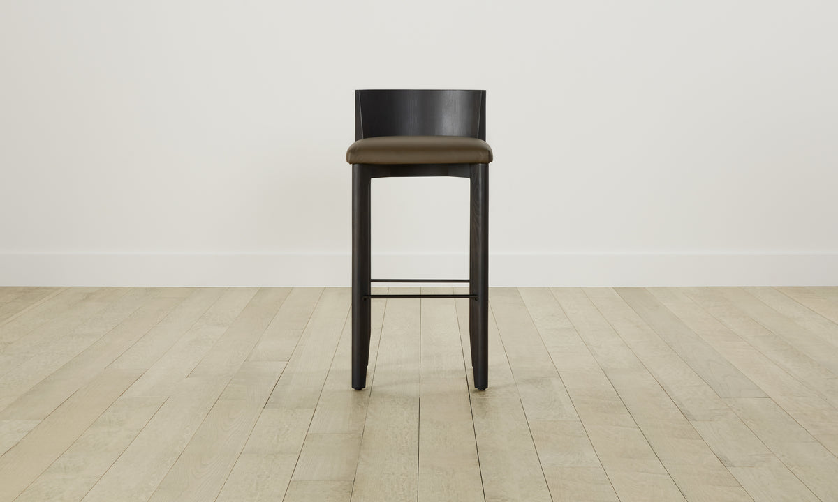 delancey barstool in black ash wood with truffle green leather seat with curved back, front view